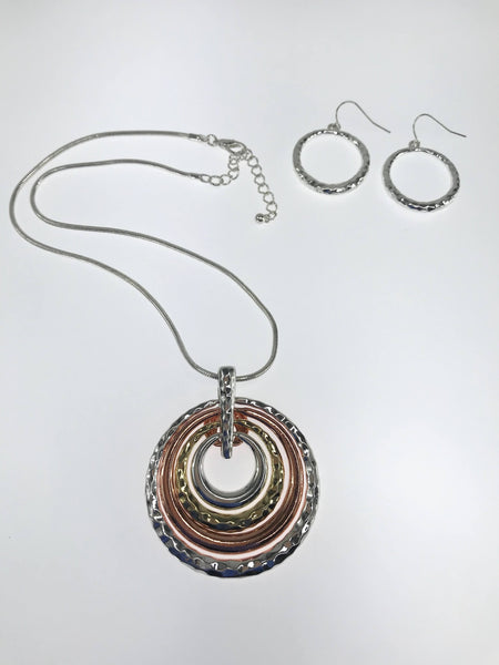 Two-tone and tri-color concentric circle pendant necklace with textured silver, gold, and bronze finishes, paired with matching hammered silver hoop earrings. The necklace features a sleek silver-tone chain with an adjustable clasp, showcasing a modern and elegant design perfect for any occasion.